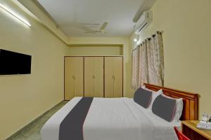 een slaapkamer met een bed en een tv bij Collection O Relax Stay Apartments in Bangalore