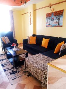 un soggiorno con un divano e un tavolino da caffè di Cosy 1 Bedroom TRM,Thika Rd a Nairobi Altre 3 foto