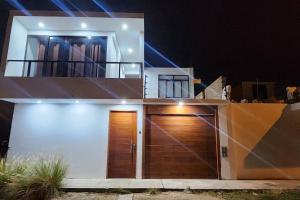 Casa grande con puerta de madera en garaje por la noche en La Duna de Emy en Ica