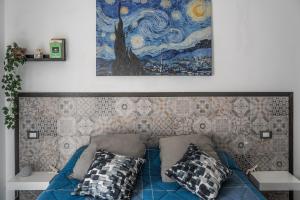 un sofá con almohadas y una pintura en la pared en Centre View en Altofonte