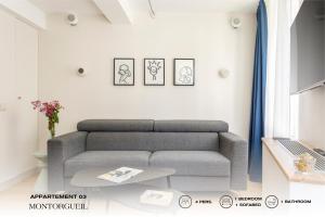 uma sala de estar com um sofá e uma mesa em Beauquartier - Montorgueil em Paris