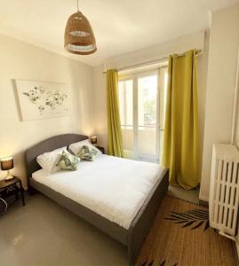 sypialnia z łóżkiem i oknem z żółtymi zasłonami w obiekcie 41m love nest for a pleasant stay in Lyon w mieście Lyon