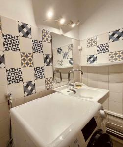 a bathroom with a sink and tiles on the wall at 41m love nest for a pleasant stay in Lyon in Lyon