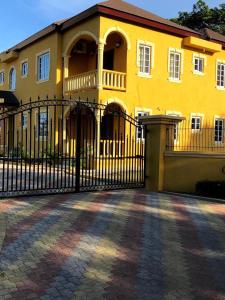 a yellow building with a gate in front of it at Azul-Lapis Lazuli in Runaway Bay