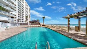 una piscina frente a un edificio y al océano en Stunning Views, 3BD/2BA w/ Private Balcony en Orange Beach