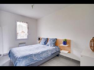 sypialnia z łóżkiem z niebieską pościelą i oknem w obiekcie Maison Caroline Arkea Arena w mieście Bouliac