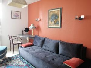 a living room with a couch and a table at Ty Pempoul - logement 2 chambres - 100 m de la plage in Saint-Pol-de-Léon