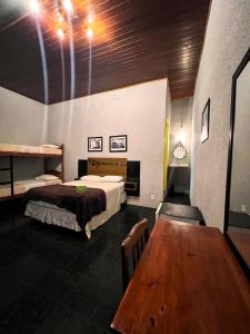 a room with two beds and a wooden table at HMG - Praia de Botafogo in Rio de Janeiro