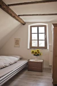 a bedroom with a bed and a vase of flowers on a table at Ferienwohnung Kaim in Prichsenstadt