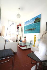 d'un salon avec un mobilier blanc et une peinture murale. dans l'établissement APPARTEMENT NICE le PORT, à Nice