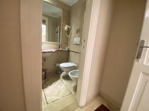 a bathroom with a toilet and a mirror at Rent rooms Saint Peter in Rome