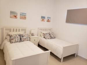 a bedroom with two beds and a table at Villa parmera ocean from in Los Corrales