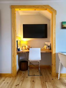 Camera con scrivania, sedia e TV. di La Petite Auberge Sur Queen a Rawdon