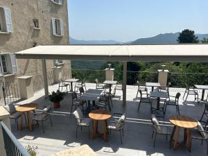 - un ensemble de tables et de chaises sur une terrasse dans l'établissement Hôtel U Frascone, à Venaco