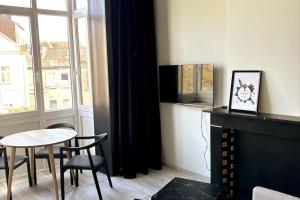 sala de estar con mesa y chimenea en Au Cabinet Childeric en Tournai