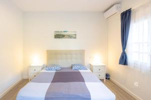 een slaapkamer met een bed met 2 nachtkastjes en een raam bij Apartment in Cabopino in Marbella