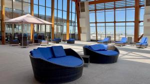 vestíbulo con sillas azules y sombrilla en un edificio en Alto del Sol Calama en Calama