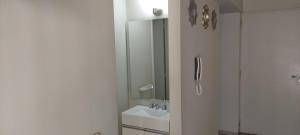 ein weißes Badezimmer mit Waschbecken und Dusche in der Unterkunft Del vino departamento in La Cieneguita + 3 Fotos