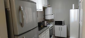 a kitchen with a refrigerator and a stove at Del vino departamento in La Cieneguita