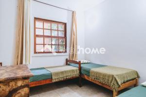 Cette chambre comprend 2 lits et une fenêtre. dans l'établissement Casa a 5 minutos da Praia Rasa, em Búzios, à São Vicente