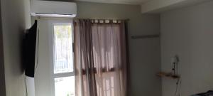 Zimmer mit einem Fenster mit einem Vorhang und einer Tür in der Unterkunft Del vino departamento in La Cieneguita