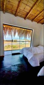 1 dormitorio con cama y ventana grande en Casa de Playa con Piscina Privada, en Los Órganos