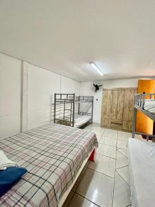 1 dormitorio con 1 cama y literas. en Pousada Alojamento AS, en Viracopos