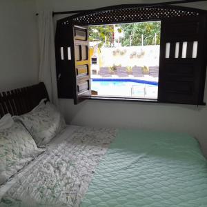 a bedroom with a bed and a view of a pool at Casa Áustria! in Salvador