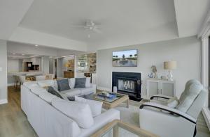 a living room with white furniture and a fireplace at 1408 Ocean Club by AvantStay Oceanfront Home w Amazing Views in Isle of Palms