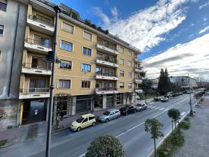 a street with cars parked in front of a building at UNODUE House in Cuneo