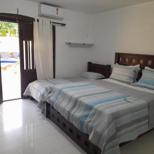 a bedroom with two beds and a sliding glass door at Casa Áustria! in Salvador