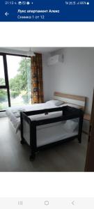 une photo d'une chambre avec un lit et une fenêtre dans l'établissement Лукс апартамент Алекс, à Blagoevgrad