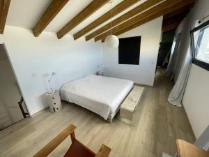 - une chambre avec un lit blanc et du parquet dans l'établissement La Kaz À Bonér !, à Saint-Leu