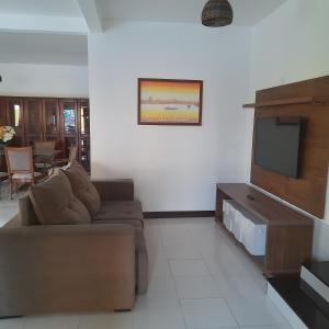 a living room with a couch and a flat screen tv at Casa Áustria! in Salvador