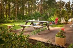 a picnic table and a bench on a wooden deck at Lauku iela 25 in Jūrmala