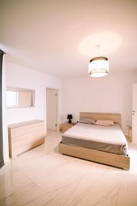 1 dormitorio con 1 cama grande y pared blanca en Spacious 3 bedroom in Sliema! en Sliema