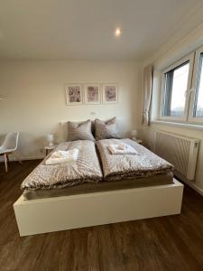 a white bed with two pillows on it in a bedroom at RK Apartment Holzova in Líšeň