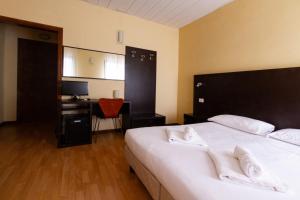 a bedroom with a large white bed with a desk at Hotel Guidi in Mestre