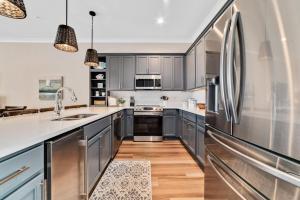 a kitchen with gray cabinets and stainless steel appliances at Newly Built, Luxury Home w/ pool & beach access in Gulf Shores