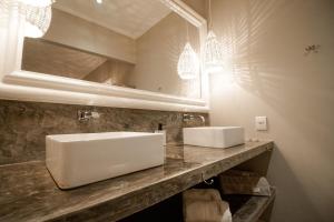 een badkamer met een witte wastafel en een spiegel bij FLAT 3 - MANGABA PIPA in Pipa