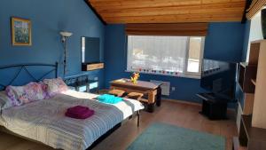a bedroom with blue walls and a bed and a table at Vakari Puhketalu in Vakari +60 photos