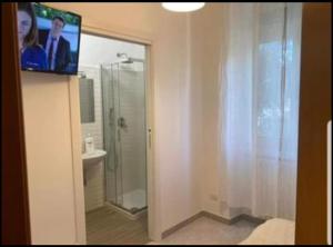 ein Bad mit einer Dusche und einem Flachbild-TV in der Unterkunft B&B Baby Park in Conversano