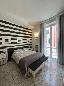 1 dormitorio con 1 cama con pared a rayas en Affittacamere Perla del Prione, en La Spezia