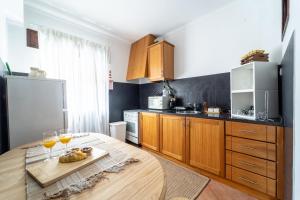 a kitchen with a wooden table with wine glasses on it at Casino and Beach Apartment by House and People in Póvoa de Varzim