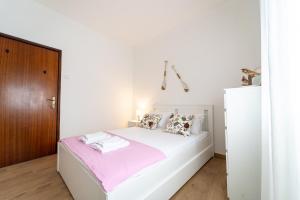 a white bedroom with a large white bed with pink sheets at Casino and Beach Apartment by House and People in Póvoa de Varzim