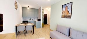 a living room and kitchen with a couch and a table at Panorama Garden in Olsztyn