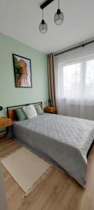 a bedroom with a large bed and a window at Panorama Garden in Olsztyn