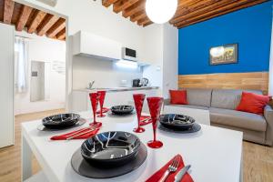 cocina y sala de estar con mesa blanca y sillas rojas en Ca' dell'Arciere Apartments, en Venecia