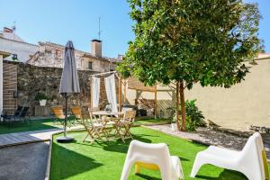 ogród ze stołem, krzesłami i parasolem w obiekcie Cal Capó alojamiento con jacuzzi w mieście Besalú