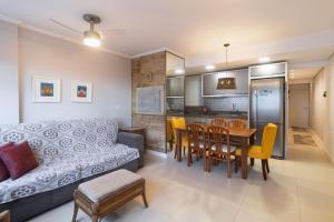 un salon avec un canapé et une table dans l'établissement Apartamento com 2 Dormitórios no Coração da Praia Grande - Torres/ RS, à Torres